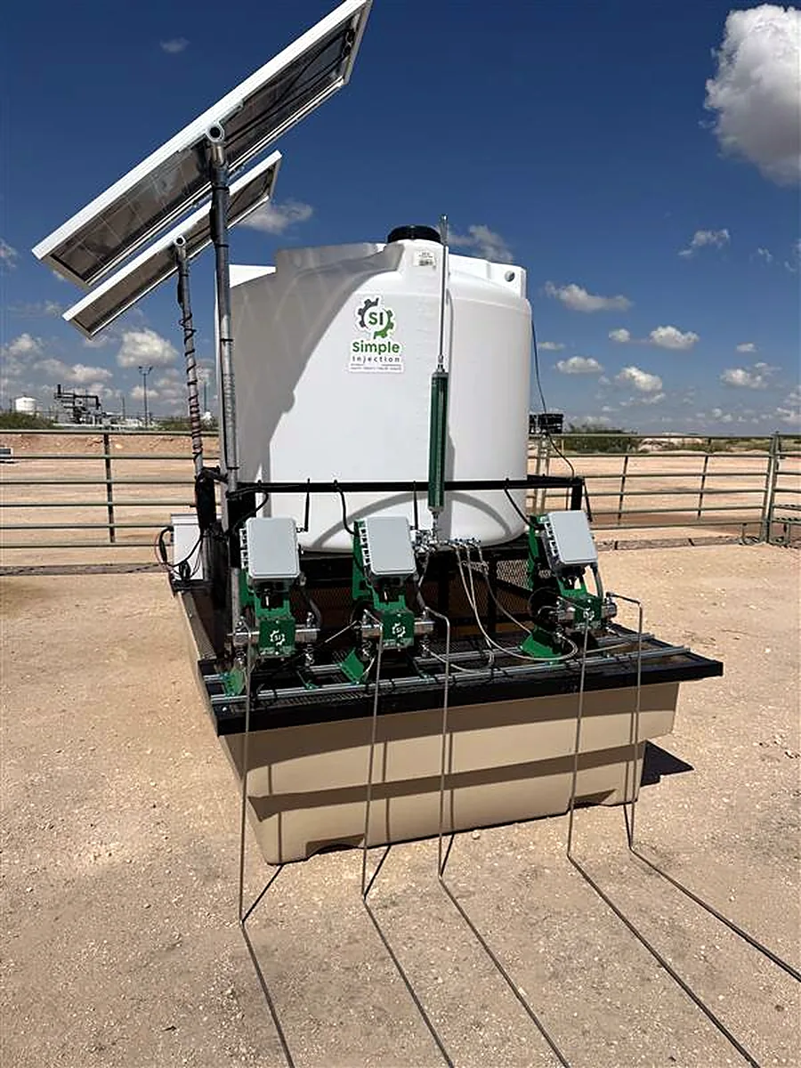 Close view of a three-pump chemical injection skid with tank, containment and solar panel
